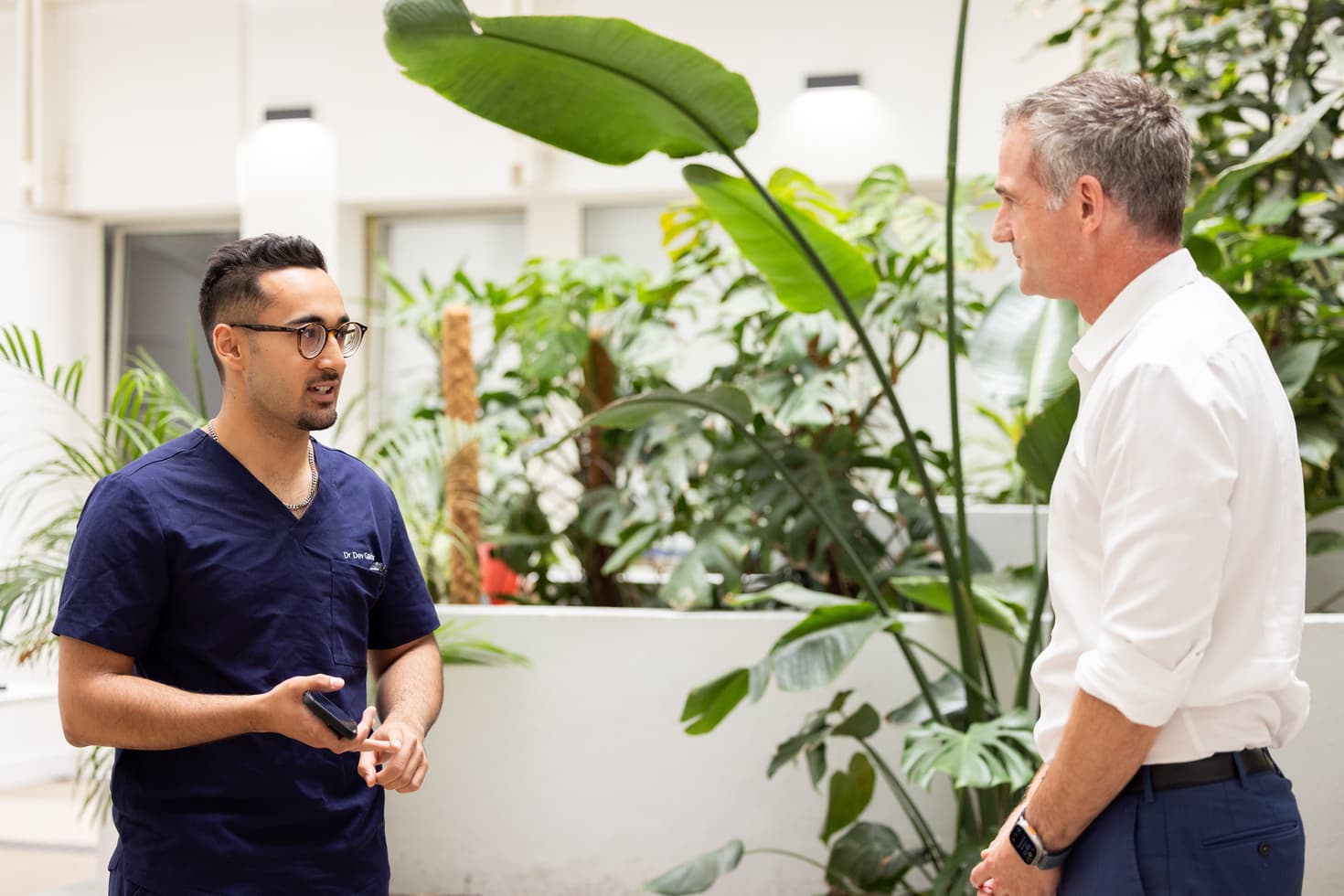 Dr Dev Gakhar filming with a colleague in a hospital atrium